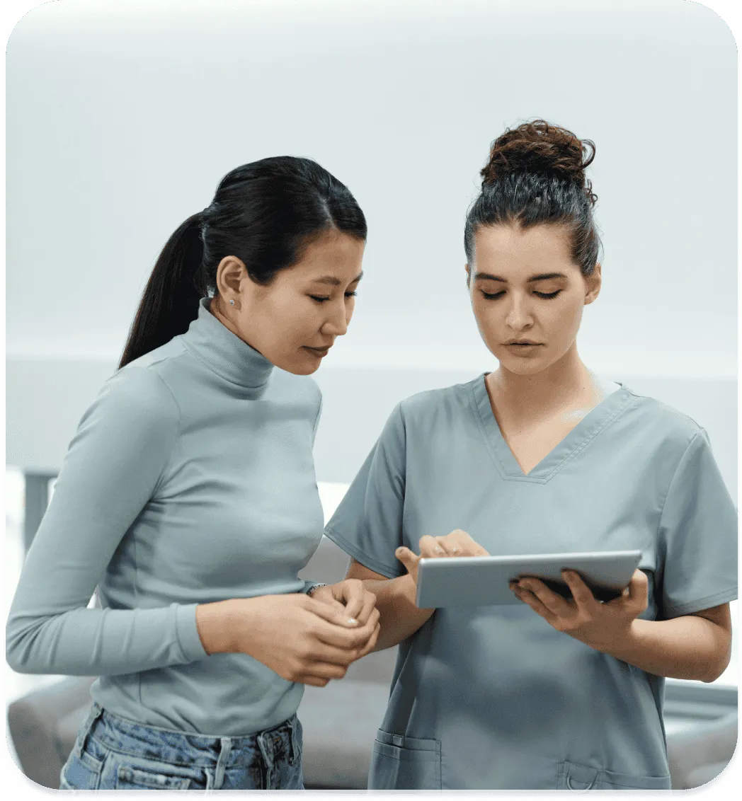 Une infirmière et une patiente consultant une tablette
